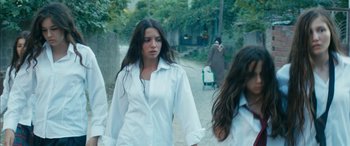 Movie still from “Mustang” (2015), directed by Deniz Gamze Ergüven – A woman walking down a street with a suitcase; Medium shot, Low angle