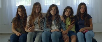 Movie still from “Mustang” (2015), directed by Deniz Gamze Ergüven – Three young girls sitting on a couch together; Medium shot, High angle