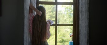 Movie still from “Mustang” (2015), directed by Deniz Gamze Ergüven – A woman brushing her long brown hair near a window; Medium shot, Over the shoulder angle