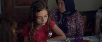 Movie still from “Mustang” (2015), directed by Deniz Gamze Ergüven – A young girl sitting next to an older woman holding a fork; Close Up shot, Over the shoulder angle