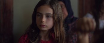 Movie still from “Mustang” (2015), directed by Deniz Gamze Ergüven – A young girl with long brown hair looking at the camera; Close Up shot, Over the shoulder angle