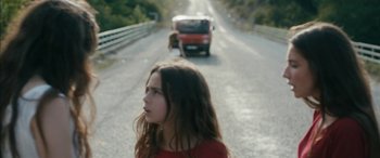 Movie still from “Mustang” (2015), directed by Deniz Gamze Ergüven – A young girl standing on the side of a road near a red van; Close Up shot, Low angle