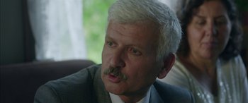 Movie still from “Mustang” (2015), directed by Deniz Gamze Ergüven – An older man in a suit and white hair; Close Up shot, Over the shoulder angle