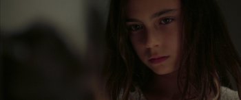 Movie still from “Mustang” (2015), directed by Deniz Gamze Ergüven – A young girl with long dark brown hair stares into the camera; Close Up shot, Over the shoulder angle