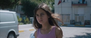 Movie still from “Mustang” (2015), directed by Deniz Gamze Ergüven – A young girl is standing outside in the sun; Close Up shot, Low angle