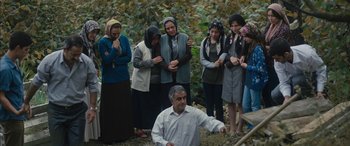 Movie still from “Mustang” (2015), directed by Deniz Gamze Ergüven – A group of people standing around a man; Wide shot, High angle