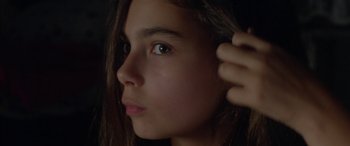 Movie still from “Mustang” (2015), directed by Deniz Gamze Ergüven – A young girl's face with her hand up to the side of her head; Close Up shot, Over the shoulder angle