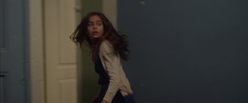 Movie still from “Mustang” (2015), directed by Deniz Gamze Ergüven – A young girl with long brown hair is standing in a room; Medium shot, Over the shoulder angle