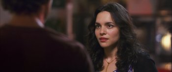 Movie still from “My Blueberry Nights” (2007), directed by Kar-Wai Wong – A beautiful woman with long black curly hair looking to her right; Close Up shot, Over the shoulder angle