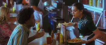 Movie still from “My Blueberry Nights” (2007), directed by Kar-Wai Wong – Two people sitting at a table with a plate of food; Medium shot, Over the shoulder angle