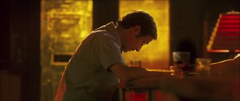 Movie still from “My Blueberry Nights” (2007), directed by Kar-Wai Wong – A man sitting at a table in front of a fire; Close Up shot, Low angle
