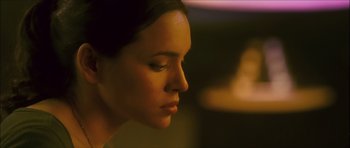 Movie still from “My Blueberry Nights” (2007), directed by Kar-Wai Wong – A woman's face in a dimly - lit room; Close Up shot, Over the shoulder angle