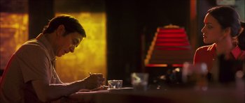 Movie still from “My Blueberry Nights” (2007), directed by Kar-Wai Wong – A man sitting at a table writing on a piece of paper; Medium shot, Low angle