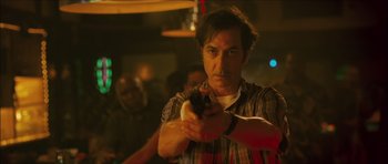 Movie still from “My Blueberry Nights” (2007), directed by Kar-Wai Wong – A man holding a gun in a room with other people; Close Up shot, Low angle