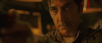 Movie still from “My Blueberry Nights” (2007), directed by Kar-Wai Wong – A man's face in a dimly - lit room; Close Up shot, Over the shoulder angle