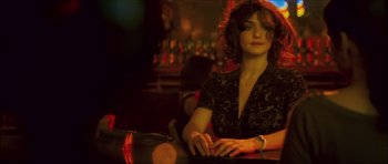 Movie still from “My Blueberry Nights” (2007), directed by Kar-Wai Wong – A woman sitting at a table in front of a bar; Close Up shot, Over the shoulder angle