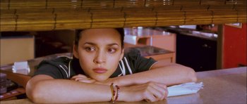 Movie still from “My Blueberry Nights” (2007), directed by Kar-Wai Wong – A woman sitting at a table with her head under the table; Close Up shot, Low angle