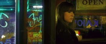 Movie still from “My Blueberry Nights” (2007), directed by Kar-Wai Wong – A woman standing in front of a window with graffiti on it; Close Up shot, Low angle