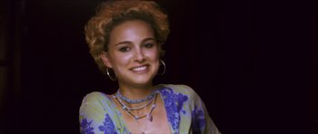 Movie still from “My Blueberry Nights” (2007), directed by Kar-Wai Wong – A woman with blonde curly hair wearing a blue and yellow dress; Close Up shot, Over the shoulder angle