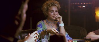 Movie still from “My Blueberry Nights” (2007), directed by Kar-Wai Wong – A woman sitting at a table with a glass of water; Close Up shot, Over the shoulder angle
