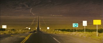 Movie still from “My Blueberry Nights” (2007), directed by Kar-Wai Wong – A road with a long street sign on the side of the road; Extreme Wide shot, High angle