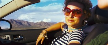 Movie still from “My Blueberry Nights” (2007), directed by Kar-Wai Wong – A woman in a car wearing sunglasses and a striped shirt; Close Up shot, Low angle