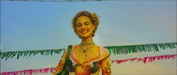 Movie still from “My Blueberry Nights” (2007), directed by Kar-Wai Wong – A woman in a colorful dress smiling for the camera; Medium shot, Low angle