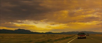 Movie still from “My Blueberry Nights” (2007), directed by Kar-Wai Wong – A road going through the middle of a field with mountains in the background; Extreme Wide shot, Low angle