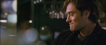 Movie still from “My Blueberry Nights” (2007), directed by Kar-Wai Wong – A person sitting in a room; Close Up shot, Over the shoulder angle