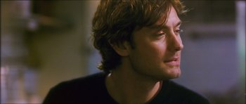 Movie still from “My Blueberry Nights” (2007), directed by Kar-Wai Wong – A man with long hair looking to his left; Close Up shot, Over the shoulder angle