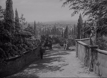 Movie still from “My Cousin Rachel” (1952), directed by Henry Koster – A black and white photo of a street scene with people on horseback; Extreme Wide shot, High angle