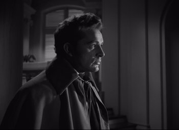 Movie still from “My Cousin Rachel” (1952), directed by Henry Koster – Black and white photograph of a man wearing a trench coat; Close Up shot, Low angle