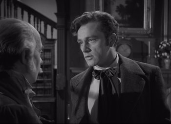 Movie still from “My Cousin Rachel” (1952), directed by Henry Koster – A man wearing a suit and a bow tie talking to another man in a suit; Close Up shot, Over the shoulder angle