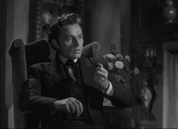 Movie still from “My Cousin Rachel” (1952), directed by Henry Koster – A man sitting in a chair holding a microphone; Close Up shot, High angle