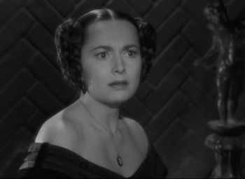 Movie still from “My Cousin Rachel” (1952), directed by Henry Koster – An old photo of an older woman in a black dress; Close Up shot, Over the shoulder angle