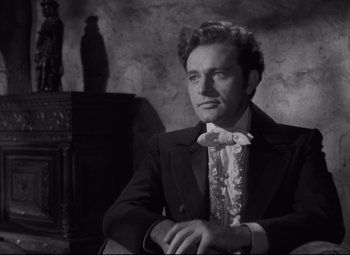 Movie still from “My Cousin Rachel” (1952), directed by Henry Koster – A man sitting in a chair wearing a suit and tie; Close Up shot, Low angle