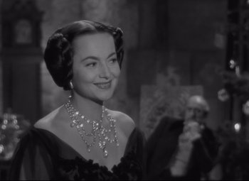 Movie still from “My Cousin Rachel” (1952), directed by Henry Koster – A woman in a black dress and a necklace; Close Up shot, Over the shoulder angle