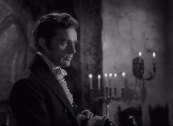Movie still from “My Cousin Rachel” (1952), directed by Henry Koster – A black and white photo of a man in a suit; Medium shot, Over the shoulder angle