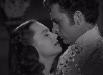 Movie still from “My Cousin Rachel” (1952), directed by Henry Koster – A black and white photo of a man and a woman kissing; Close Up shot, Over the shoulder angle