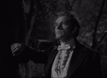 Movie still from “My Cousin Rachel” (1952), directed by Henry Koster – A black and white photo of a man in a suit and bow tie; Medium shot, Low angle