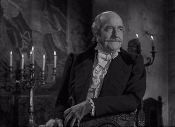 Movie still from “My Cousin Rachel” (1952), directed by Henry Koster – An older man in a suit and tie sitting in a chair; Medium shot, Over the shoulder angle