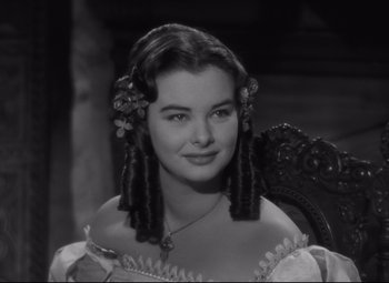 Movie still from “My Cousin Rachel” (1952), directed by Henry Koster – A young woman with long hair sitting in a chair; Close Up shot, Over the shoulder angle