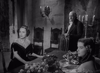 Movie still from “My Cousin Rachel” (1952), directed by Henry Koster – An old photo of a family sitting at a dinner table; Medium shot, Over the shoulder angle