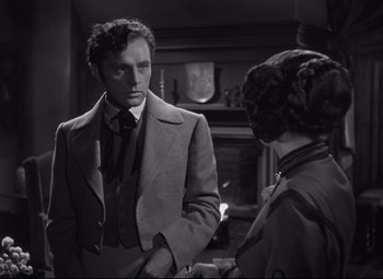 Movie still from “My Cousin Rachel” (1952), directed by Henry Koster – A man and a woman standing next to each other in front of a fireplace; Medium shot, Over the shoulder angle