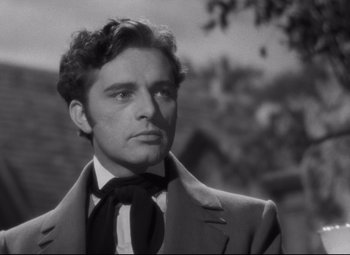 Movie still from “My Cousin Rachel” (1952), directed by Henry Koster – A man wearing a suit and tie looking to his left; Close Up shot, Over the shoulder angle