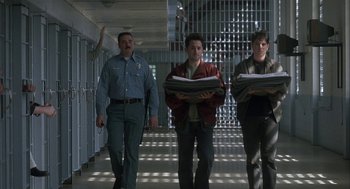 Movie still from “My Cousin Vinny” (1992), directed by Jonathan Lynn – A group of men walking down a hallway holding papers; Wide shot, Low angle