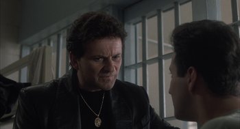 Movie still from “My Cousin Vinny” (1992), directed by Jonathan Lynn – A man in a leather jacket talking to another man in front of a window; Close Up shot, Low angle