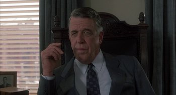 Movie still from “My Cousin Vinny” (1992), directed by Jonathan Lynn – An older man wearing a suit and tie while holding a cell phone to his ear; Close Up shot, Low angle