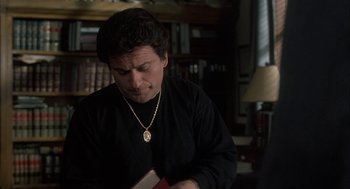 Movie still from “My Cousin Vinny” (1992), directed by Jonathan Lynn – A man in a black shirt is holding a book; Close Up shot, High angle