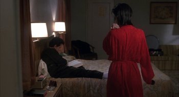 Movie still from “My Cousin Vinny” (1992), directed by Jonathan Lynn – A woman in a red bathrobe standing next to a man in a black robe; Medium shot, Over the shoulder angle